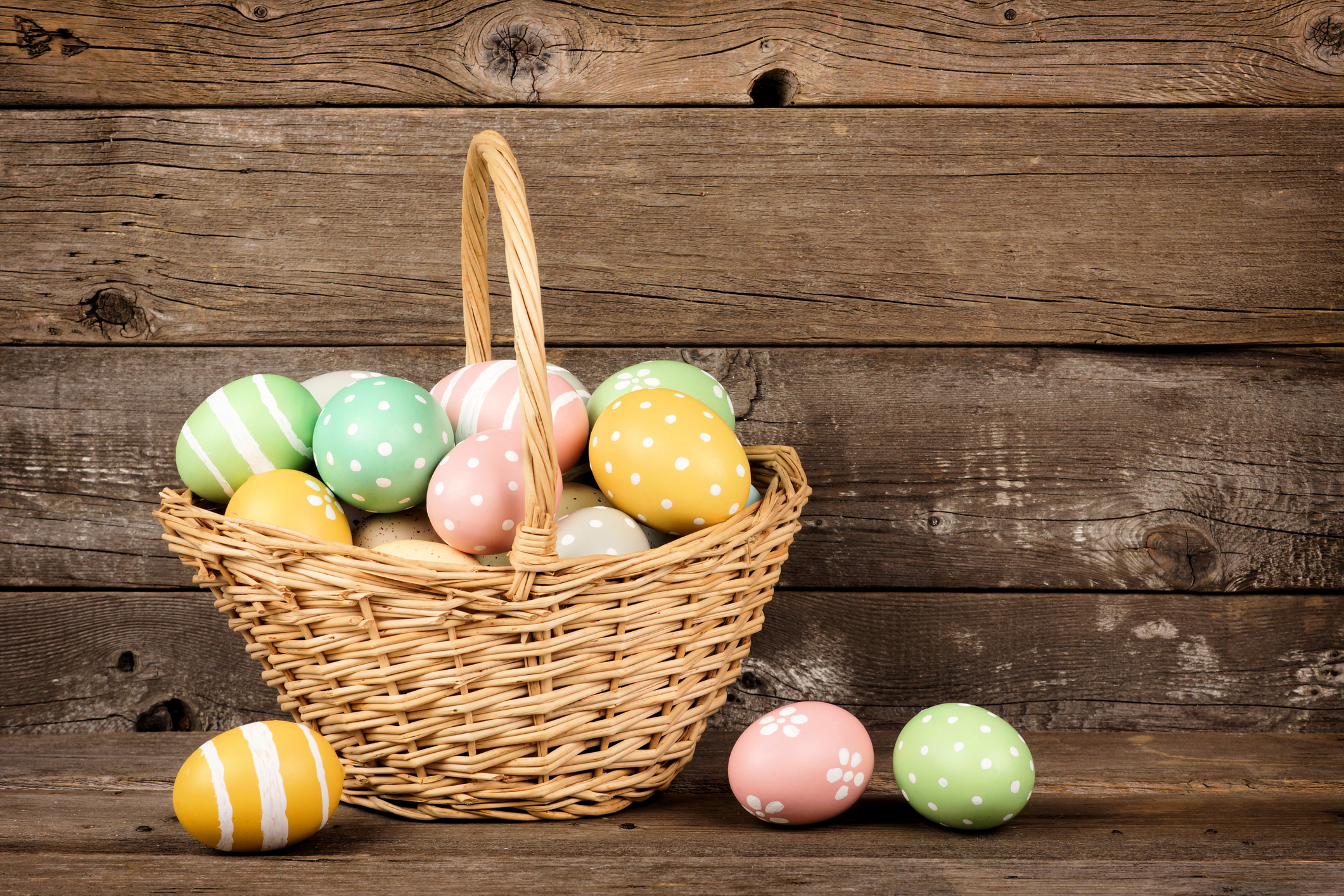 Easter basket filled eggs over rustic wood